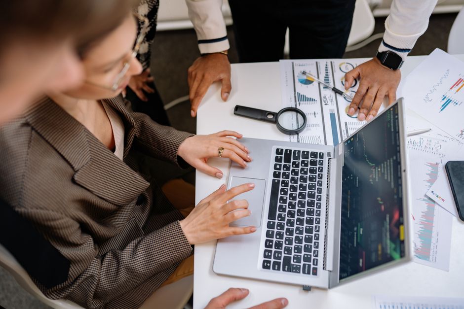 Korporativni profesionalci analiziraju podatke na laptopu radeći na strategijama projekta