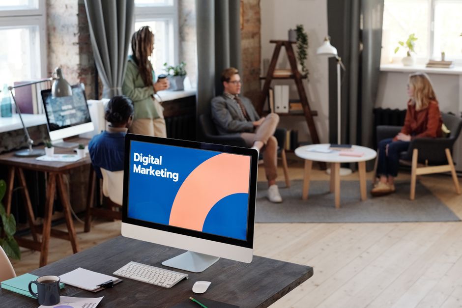 Group of colleagues discussing digital marketing strategies in an office setting.