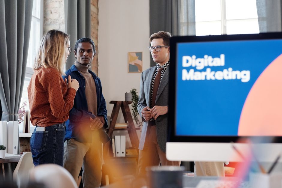 Grupa kolega raspravlja o digitalnim marketinškim strategijama u uredu